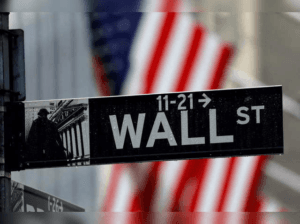 Imaginea capturată pe Wall Street, cu un steag american în fundal, simbolizează centrul financiar al lumii, unde deciziile importante influențează piețele globale și economiile naționale.