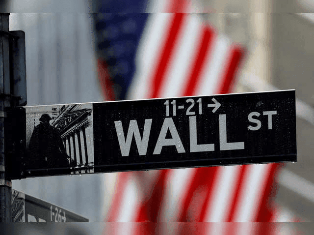 Imaginea capturată pe Wall Street, cu un steag american în fundal, simbolizează centrul financiar al lumii, unde deciziile importante influențează piețele globale și economiile naționale.